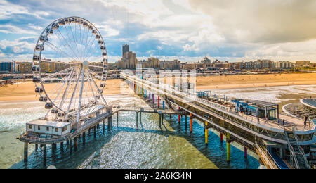 Scheveningen, l'Aia, Paesi Bassi. Ruota panoramica Ferris e il molo presso la spiaggia. Foto Stock