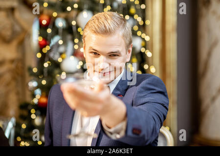 Ritratto di un uomo elegante con coppetta Martini alla vigilia dell'anno nuovo celebrando presso il ristorante di lusso Foto Stock