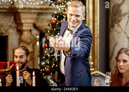 Ritratto di un uomo elegante con coppetta Martini alla vigilia dell'anno nuovo celebrando presso il ristorante di lusso Foto Stock