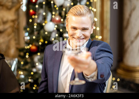 Ritratto di un uomo elegante con coppetta Martini alla vigilia dell'anno nuovo celebrando presso il ristorante di lusso Foto Stock