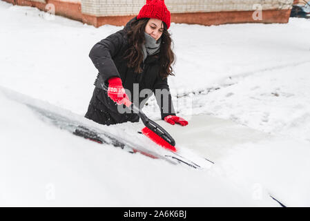 Donna auto pulita con una spazzola dopo neve Foto Stock