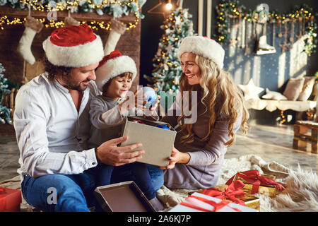 Emozionato genitori con bambini presenta apertura Foto Stock