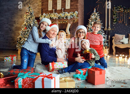 Nonna e nonno con i bambini a casa durante il periodo di Natale. Foto Stock