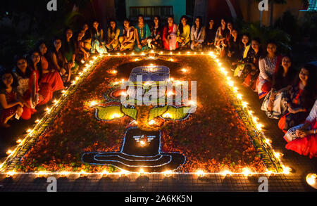 Assam, India. Ottobre 27, 2019. Gli studenti della Università di cotone decorare Rangoli con Diyas (earthern lampade) in occasione della festa di Diwali a Guwahati domenica. Foto: David Talukdar/ Alamy Live News Foto Stock