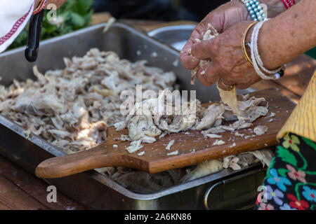 Vecchia donna disossare la carne di pollo per la tradizionale zuppa bulgara chiamato Kurban. Foto Stock