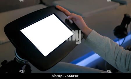 Donna che guarda sul pavimento nero chiosco tablet con vuoto display bianco Foto Stock