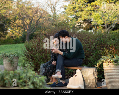 Rabu Rabu è come dicono lovey dovey in giapponese. Un giovane viene rabu rabu mentre è seduto su una panchina in Enoshima. Foto Stock