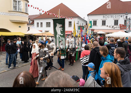 Un cavaliere di indossare la corazza e la sua signora camminando mano nella mano, guardato dal pubblico, Eggenburg Festival medievale, Austria il più grande evento medievale Foto Stock