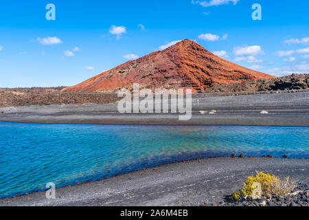 Paesaggio con rosso vulcano vicino a Los Hervideros grotte a Lanzarote, Isole Canarie, Spagna Foto Stock