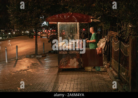 Il Kosovo, Pristina bazar. Il vecchio uomo vendere il mais di notte Foto Stock