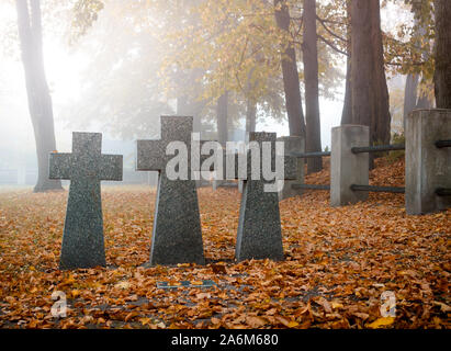 Il granito grigio attraversa su un soldato tedesco tomba. Tombe di soldati sconosciuti sul cimitero militare a Kiev, Ucraina. Mattina autunnale scena Foto Stock