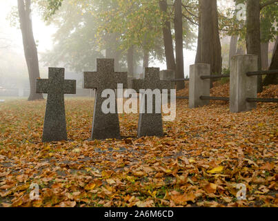 Il granito grigio attraversa su un soldato tedesco tomba. Tombe di soldati sconosciuti sul cimitero militare a Kiev, Ucraina. Mattina autunnale scena Foto Stock