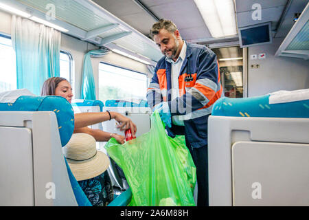 Valencia Spagna,Estacio del Nord,treno Renfe,cabina interna,dipendente di servizio a bordo,passeggero,uomo,donna,raccolta rifiuti,ispanico,ES190831078 Foto Stock