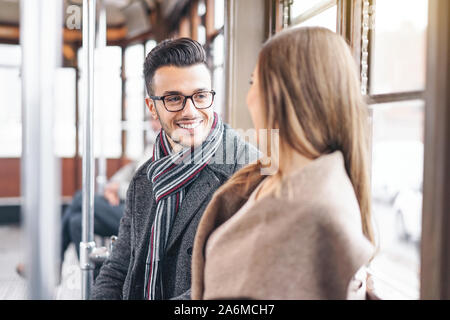 Coppia giovane avente una conversazione mentre è seduto all'interno di vintage trasporti tram - le persone felici parlando durante un viaggio in autobus dal centro città Foto Stock