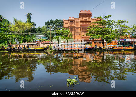 Alappuzha, India - 14 Novembre 2017: barche lungo il canale principale con orange hotel edificio nel centro di Alleppey Foto Stock