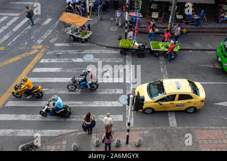 Medellín, Antioquia /Colombia, 28 Gennaio 2019: ambulanti, Passerbies, motocicli e Taxi a La strada commerciale vicino alla stazione di Santa Lucía su Foto Stock