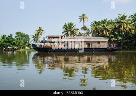 Casa galleggiante tradizionale del Kerala backwaters lungo la struttura Palm Tree costa a un limpido giorno soleggiato, Alappuzha, Cochin, India Foto Stock