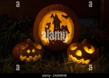 Funny zucche di Halloween con scary house e i volti Foto Stock