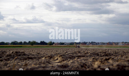 Il contadino arando la terra asciutta con un vecchio trattore in background. Agricola, siccità, dissodamento del terreno, agricoltura e agricoltura rurale scena. Unione coun Foto Stock