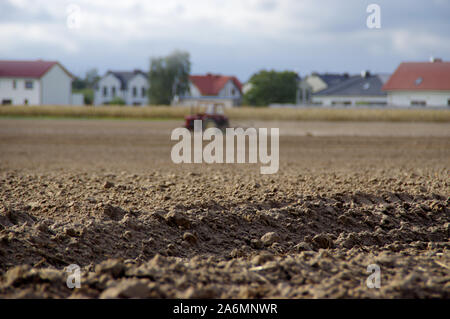 Il contadino arando la terra asciutta con un vecchio trattore in background. Agricola, siccità, dissodamento del terreno, agricoltura e agricoltura rurale scena. Unione coun Foto Stock