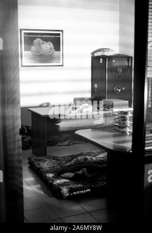 L'ufficio dell' ex proprietario è stato usato come una camera da letto durante il sequestro. Cooperativa El Aguante, Carapachay, Buenos Aires, Argentina. Maggio 2002. Foto Stock