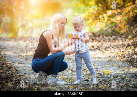 Sua madre e la sua figlia in autunno a park - famiglia sfondi Foto Stock
