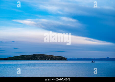 L Aymara uomo Paddling e la pesca in una piccola barca nella pittoresca baia di Challa Situato nel famoso Sun Island (Isla del Sol) Foto Stock