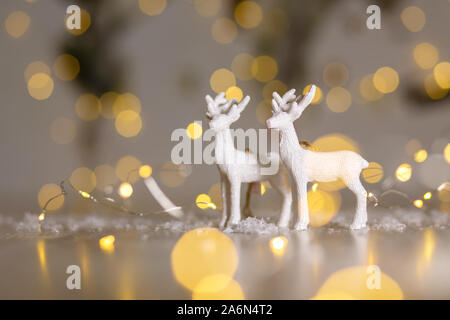 Decorazione di Natale figurine a tema. Natale cervi. Decorazione per albero di Natale. Decorazioni festive, calde luci bokeh di fondo Foto Stock