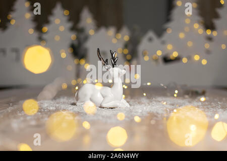 Decorazione di Natale figurine a tema. Natale cervi. Decorazione per albero di Natale. Decorazioni festive, calde luci bokeh di fondo Foto Stock