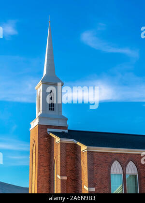In prossimità della parte esterna della chiesa con il campanile e il rosso mattone muro contro il cielo blu Foto Stock