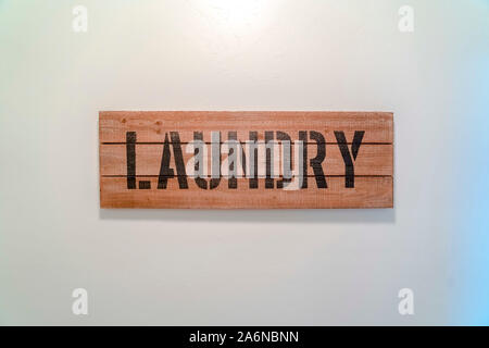 Legno verniciato Servizio lavanderia segno sul muro bianco Foto Stock
