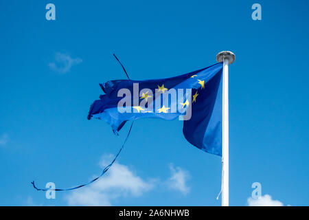 Danneggiato bandiera europea sul polo nell'aria. Questa bandiera europea descrivere i problemi della comunità è rivolta ora. Foto Stock