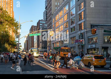 NEW YORK CITY - circa 2019: traffico di persone e di veicoli affollano l'incrocio occupato sulla quattordicesima strada nei pressi di Union Square Park nell'East Village quartiere di M Foto Stock