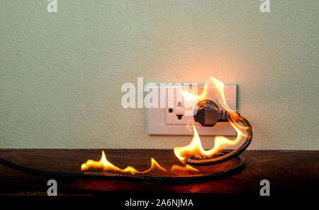 Sul fuoco il filo elettrico spina femmina parete,corto circuito elettrico a guasto derivante in elettricità filo bruciato Foto Stock