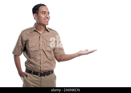 Lavoratore indonesiano con kaki uniforme di presentazione per la copia in bianco spazio sorridente Foto Stock