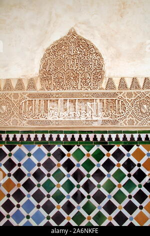 Alicatado piastrelle geometriche e stucco carving su una parete nell'Alhambra Palace, Granada, Andalusia, Spagna Foto Stock