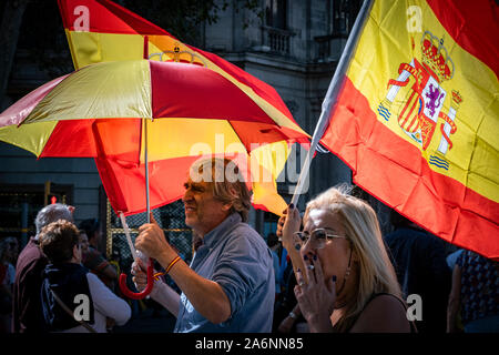 Barcellona, Spagna. 27 ott 2019. Manifestanti con bandiere spagnole e un ombrello durante la dimostrazione.Grande mobilitazione costituzionale di Barcellona. Secondo fonti di guardia urbana, la dimostrazione ha riunito 80.000 persone che hanno dimostrato sotto il motto: Per la concordia, per la Catalogna, abbastanza! Credito: SOPA Immagini limitata/Alamy Live News Foto Stock