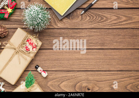 Realizzato a mano DIY confezione regalo e Addobbi Natale su uno sfondo di legno. Presente naturale scatole per Natale e Capodanno o altro anniversario. Saluto auto Foto Stock