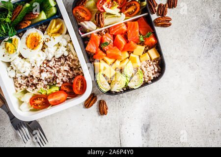 Scatola di pranzo con equilibrio di cibo sano, vista dall'alto. Riso con pesce, uova, formaggio e verdure in contenitori per alimenti. Foto Stock