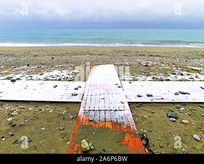 Coperta di neve piattaforme in legno formano una croce, su una spiaggia in inverno, Pieria, Grecia. Foto Stock