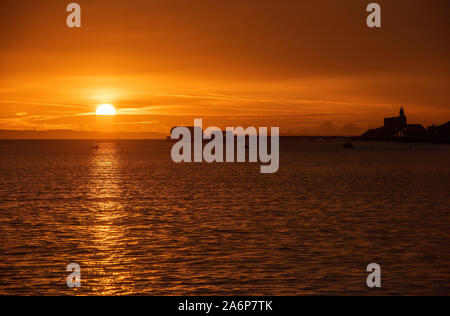 Swansea, Regno Unito. 28 ott 2019. Il sole autunnale si innalza al di sopra del mare nel piccolo villaggio sul mare di Mumbles vicino a Swansea questa mattina. Credito: Phil Rees/Alamy Live News Foto Stock