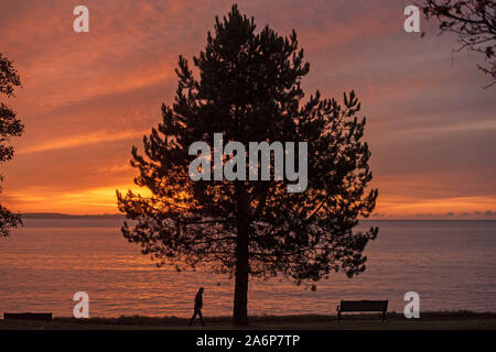 Swansea, Regno Unito. 28 ott 2019. Il sole autunnale si innalza al di sopra del mare nel piccolo villaggio sul mare di Mumbles vicino a Swansea questa mattina. Credito: Phil Rees/Alamy Live News Foto Stock