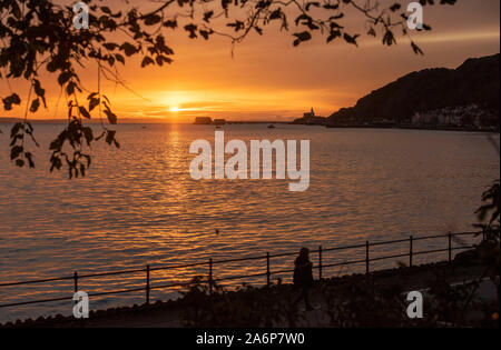 Swansea, Regno Unito. 28 ott 2019. Il sole autunnale si innalza al di sopra del mare nel piccolo villaggio sul mare di Mumbles vicino a Swansea questa mattina. Credito: Phil Rees/Alamy Live News Foto Stock