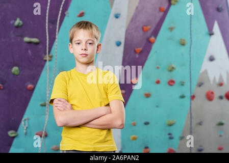 Grave schoolboy bracci di attraversamento dal petto mentre in piedi nella parte anteriore della fotocamera Foto Stock