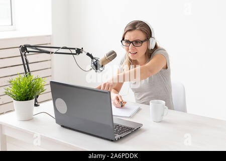 Radio, dj, blogger e concetto di persone - una giovane donna presenter lavorando sullo studio radio e parlare al microfono Foto Stock