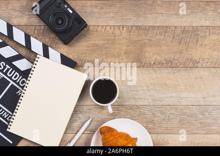 Filmato battaglio con carta e penna, torta e tazza di caffè su tavole di legno sfondo Foto Stock