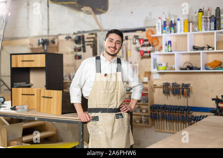 Mobili fabbrica, piccole aziende e persone concetto - Ritratto di un sorridente lavoratore di sesso maschile in fase di fabbricazione Foto Stock