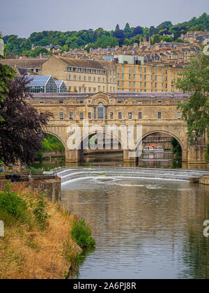 Pulteney Bridge che attraversa il fiume Avon a Bath, con lo stramazzo Pulteney in primo piano. Somerset. Foto Stock