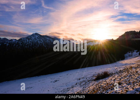 Tramonto panoramico con sunray oltre le Alpi bavaresi vicino a Tegernsee Foto Stock