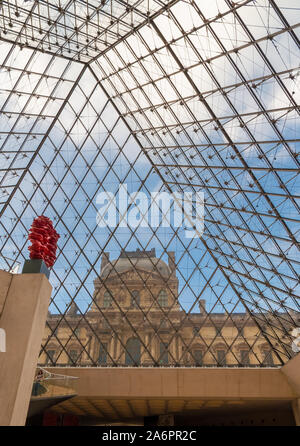 Una grande visualizzazione verticale dell'Ala Richelieu attraverso il vetro della piramide del Louvre a Parigi dalla metropolitana lobby con la scultura rosso contro di... Foto Stock